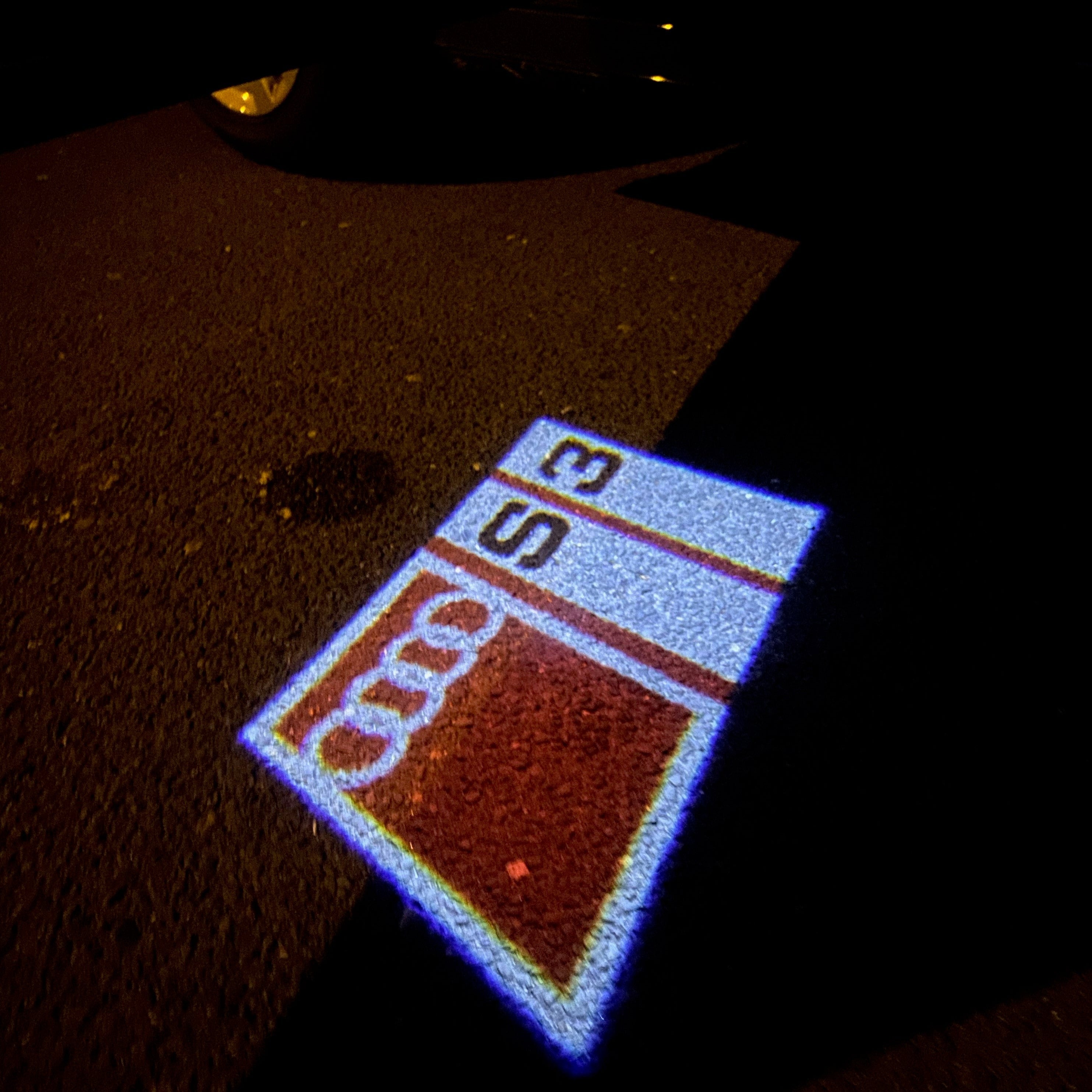 LUCES DE PROYECTOR LOGO AUDI No 153 (cantidad 1 = 2 películas con logotipo / 2 luces de puerta)